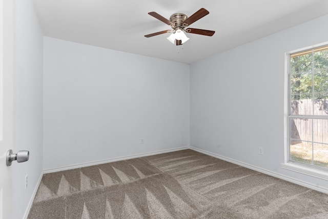 carpeted empty room featuring ceiling fan and a wealth of natural light