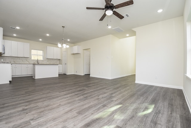 unfurnished living room with wood-type flooring, ceiling fan with notable chandelier, and sink