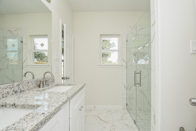 bathroom with a shower with shower door, vanity, and a healthy amount of sunlight