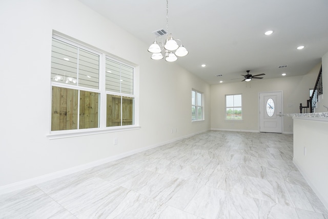 interior space featuring ceiling fan with notable chandelier