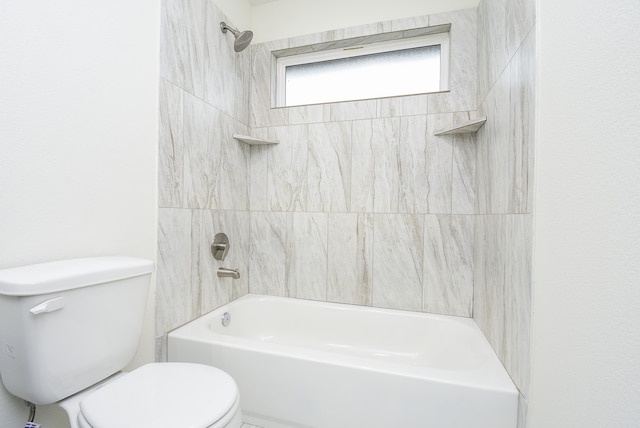 bathroom with toilet and tiled shower / bath