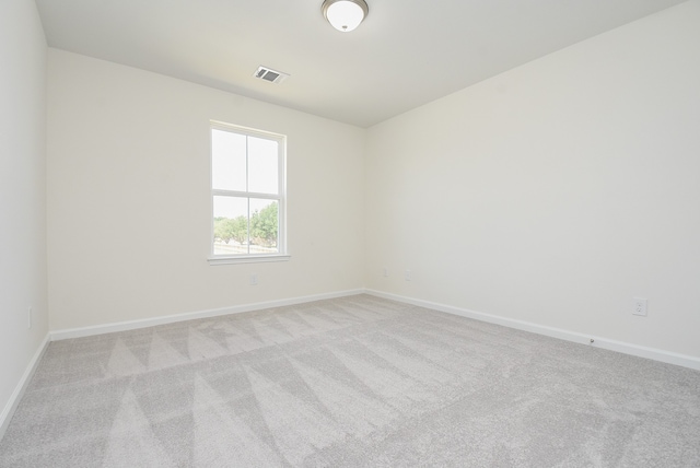 spare room featuring light colored carpet