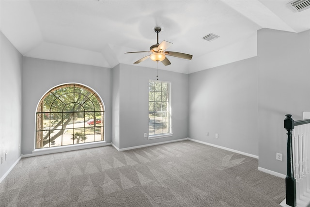 unfurnished living room featuring a wealth of natural light, ceiling fan, light colored carpet, and vaulted ceiling