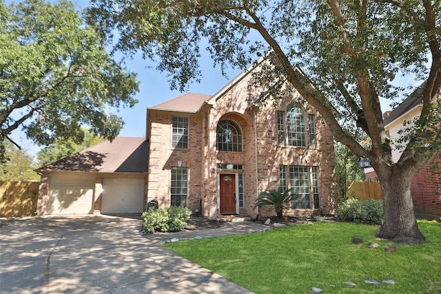 12546 Castlestone Dr, Houston, TX 77065 - traditional-style home with a front yard, a garage, brick siding, fence, and concrete driveway