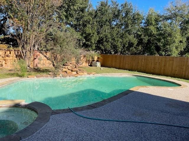 view of swimming pool featuring a patio area and an in ground hot tub