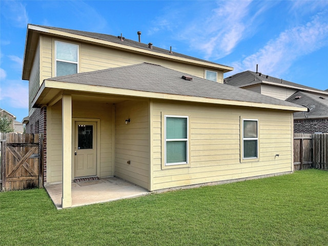 back of house with a patio and a lawn