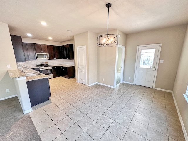 kitchen featuring decorative backsplash, dark brown cabinets, a notable chandelier, decorative light fixtures, and appliances with stainless steel finishes