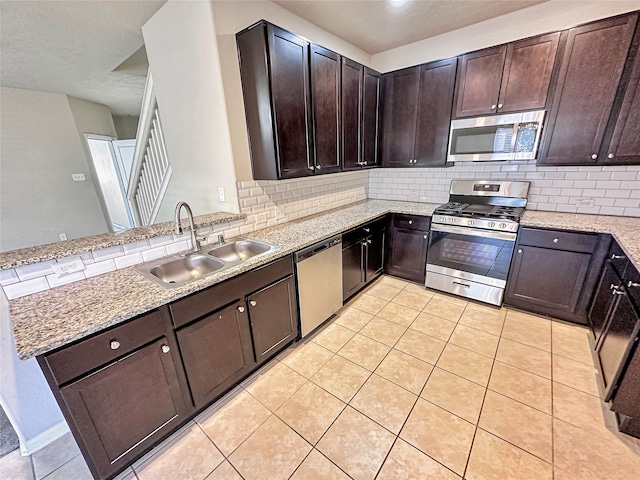 kitchen with sink, dark brown cabinetry, stainless steel appliances, and tasteful backsplash