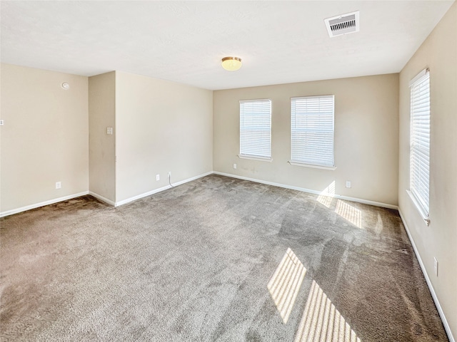 empty room with a healthy amount of sunlight and carpet