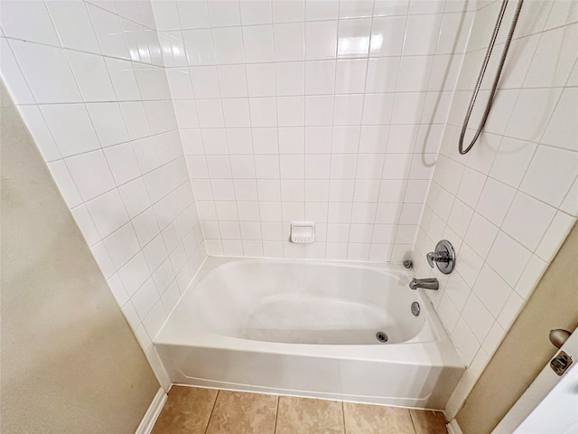 bathroom featuring tiled shower / bath combo and tile patterned flooring