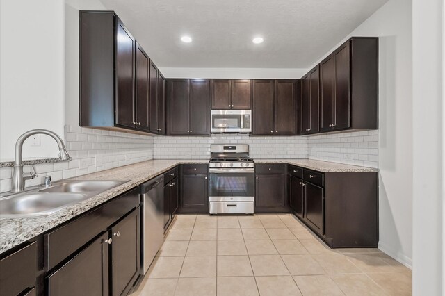 10 Garden Ridge Ct, Manvel, TX 77578 - kitchen featuring stainless steel appliances, a sink, light tile patterned floors, and decorative backsplash