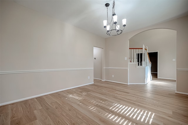 empty room with an inviting chandelier and light wood-type flooring