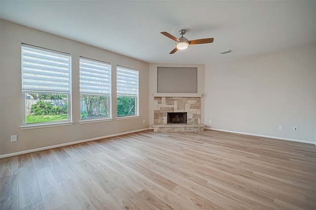 unfurnished living room featuring light hardwood / wood-style flooring, a fireplace, and ceiling fan