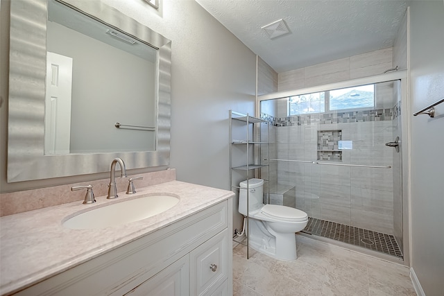 bathroom featuring tile patterned floors, toilet, vanity, a textured ceiling, and an enclosed shower