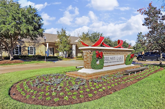 community / neighborhood sign featuring a lawn