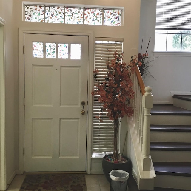 tiled entrance foyer with baseboards and stairway