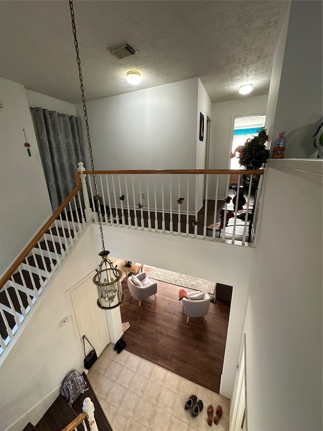 staircase with hardwood / wood-style flooring and a textured ceiling