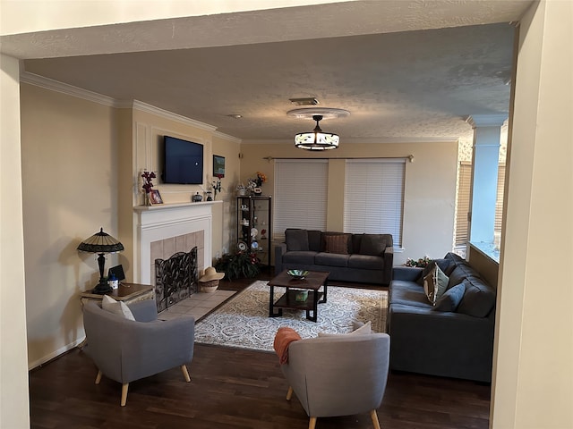 living room with hardwood / wood-style flooring, ornamental molding, and a fireplace