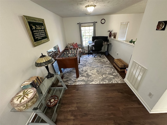 interior space with a textured ceiling and dark hardwood / wood-style flooring