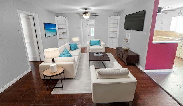 living room with dark wood-type flooring, ceiling fan, and sink