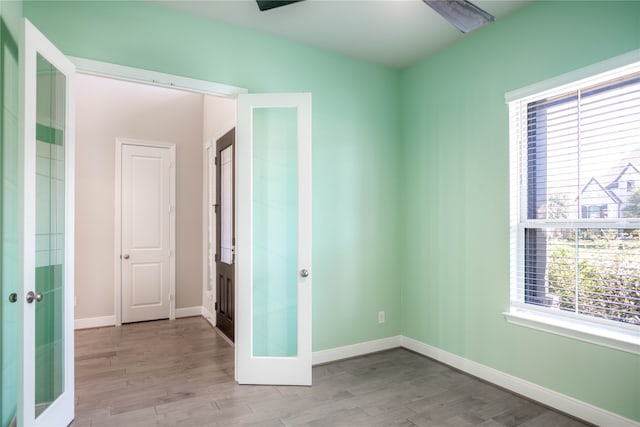 spare room featuring french doors and light hardwood / wood-style floors