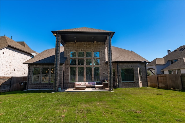 rear view of house featuring an outdoor living space, a patio, and a lawn