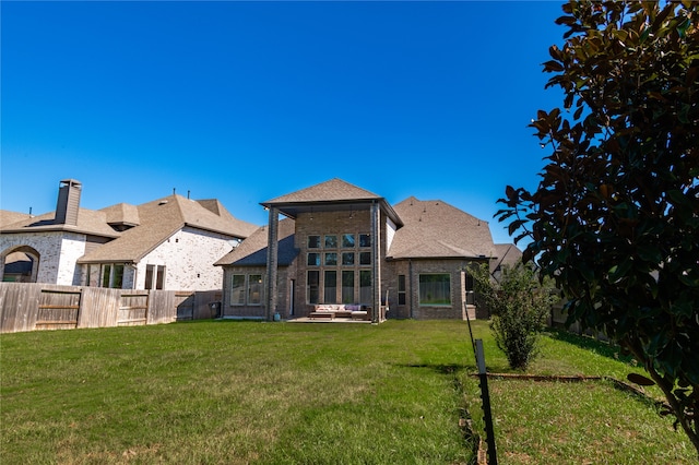 rear view of property featuring a patio and a lawn