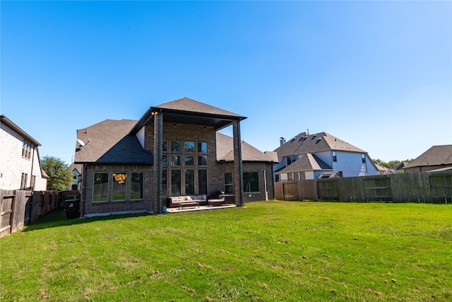 rear view of house featuring a patio and a lawn