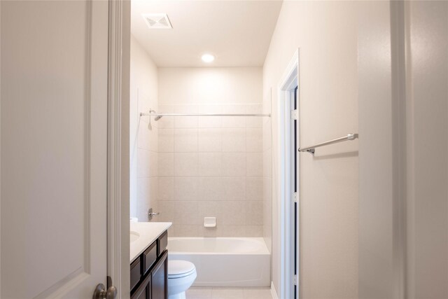 full bathroom with toilet, tiled shower / bath, vanity, and tile patterned flooring