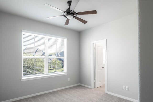 carpeted spare room with ceiling fan