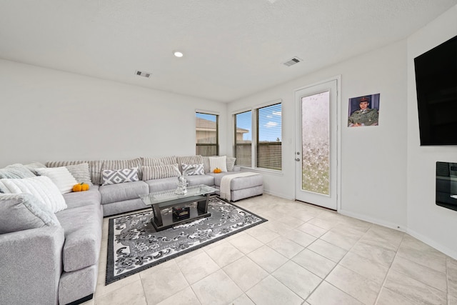 tiled living room featuring a textured ceiling