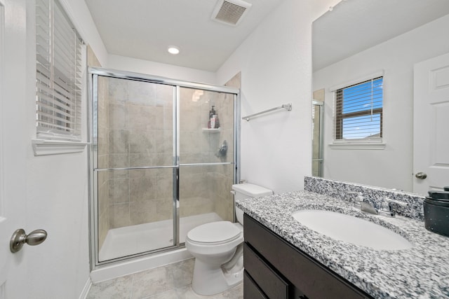 bathroom with an enclosed shower, vanity, tile patterned flooring, and toilet