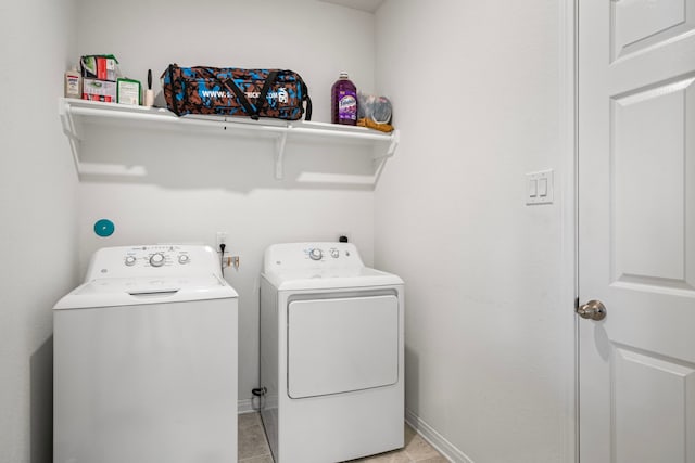 clothes washing area with washing machine and clothes dryer and light tile patterned floors