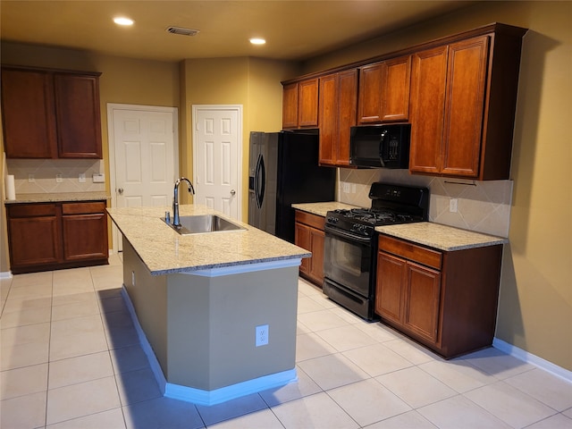 kitchen with an island with sink, backsplash, sink, and black appliances