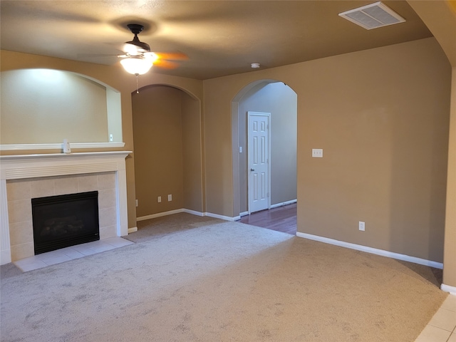 unfurnished living room featuring light carpet, a fireplace, and ceiling fan