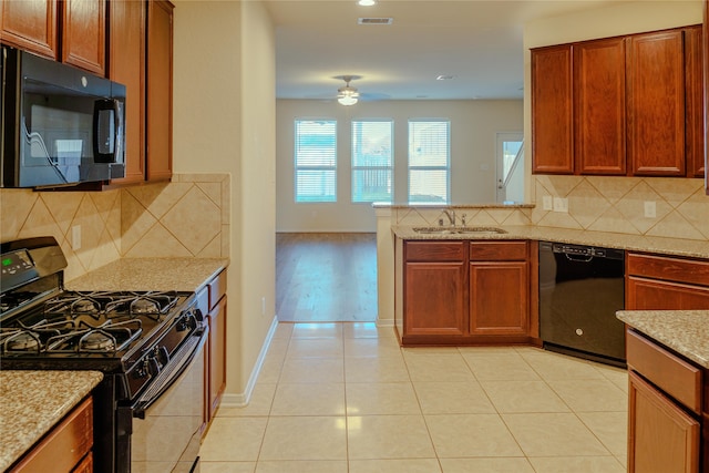 kitchen featuring sink, black appliances, light stone countertops, light wood-type flooring, and ceiling fan