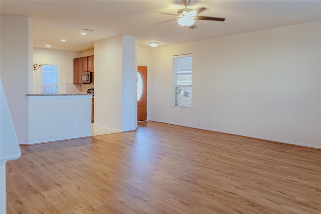 unfurnished living room with light hardwood / wood-style floors and ceiling fan