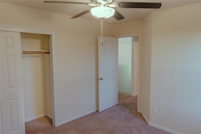 unfurnished bedroom featuring light carpet, a closet, and ceiling fan