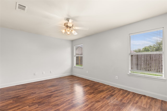 empty room featuring dark hardwood / wood-style floors, a wealth of natural light, and ceiling fan