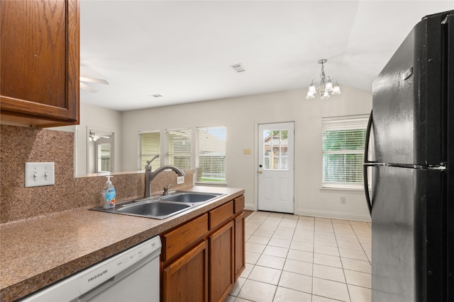 kitchen with black refrigerator, tasteful backsplash, ceiling fan with notable chandelier, sink, and dishwasher