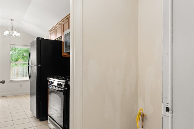 kitchen with light tile patterned flooring, range with gas cooktop, vaulted ceiling, hanging light fixtures, and stainless steel microwave