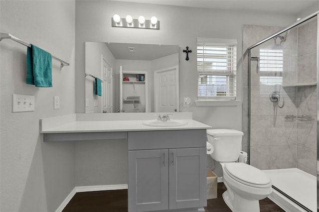 bathroom with vanity, baseboard heating, hardwood / wood-style flooring, toilet, and a shower with door