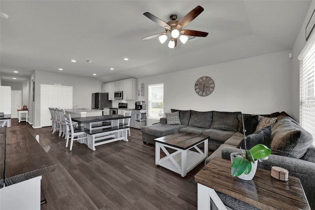 living room featuring ceiling fan and dark wood-type flooring