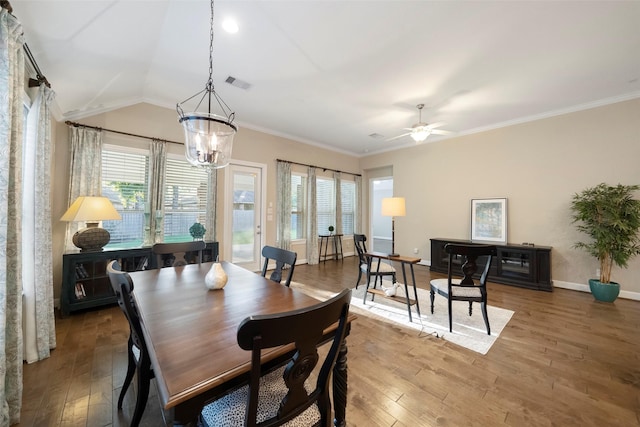 dining space with hardwood / wood-style flooring, crown molding, and vaulted ceiling