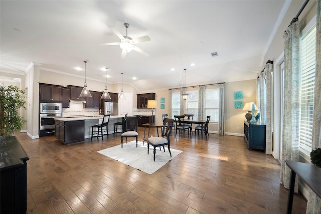 dining space with dark wood-type flooring, ceiling fan, and crown molding