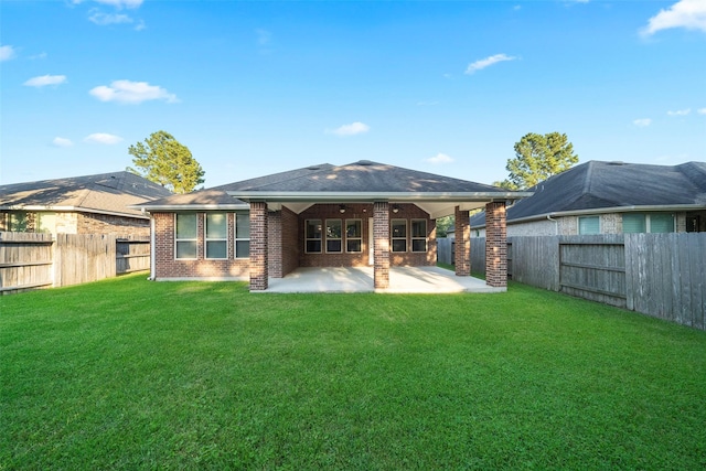 rear view of property with a yard and a patio area