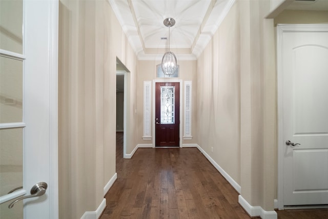 foyer with crown molding, a chandelier, and dark hardwood / wood-style flooring