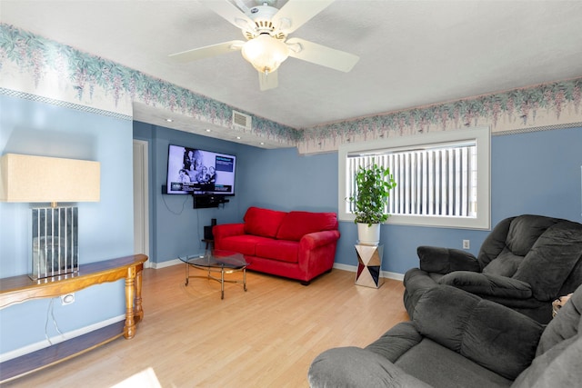 living room featuring wood-type flooring and ceiling fan