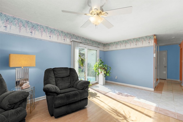 sitting room featuring ceiling fan, light hardwood / wood-style flooring, and a textured ceiling