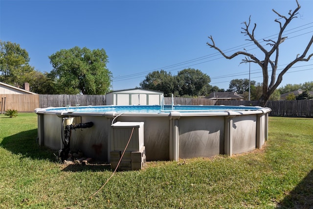 view of pool with a yard and a storage unit